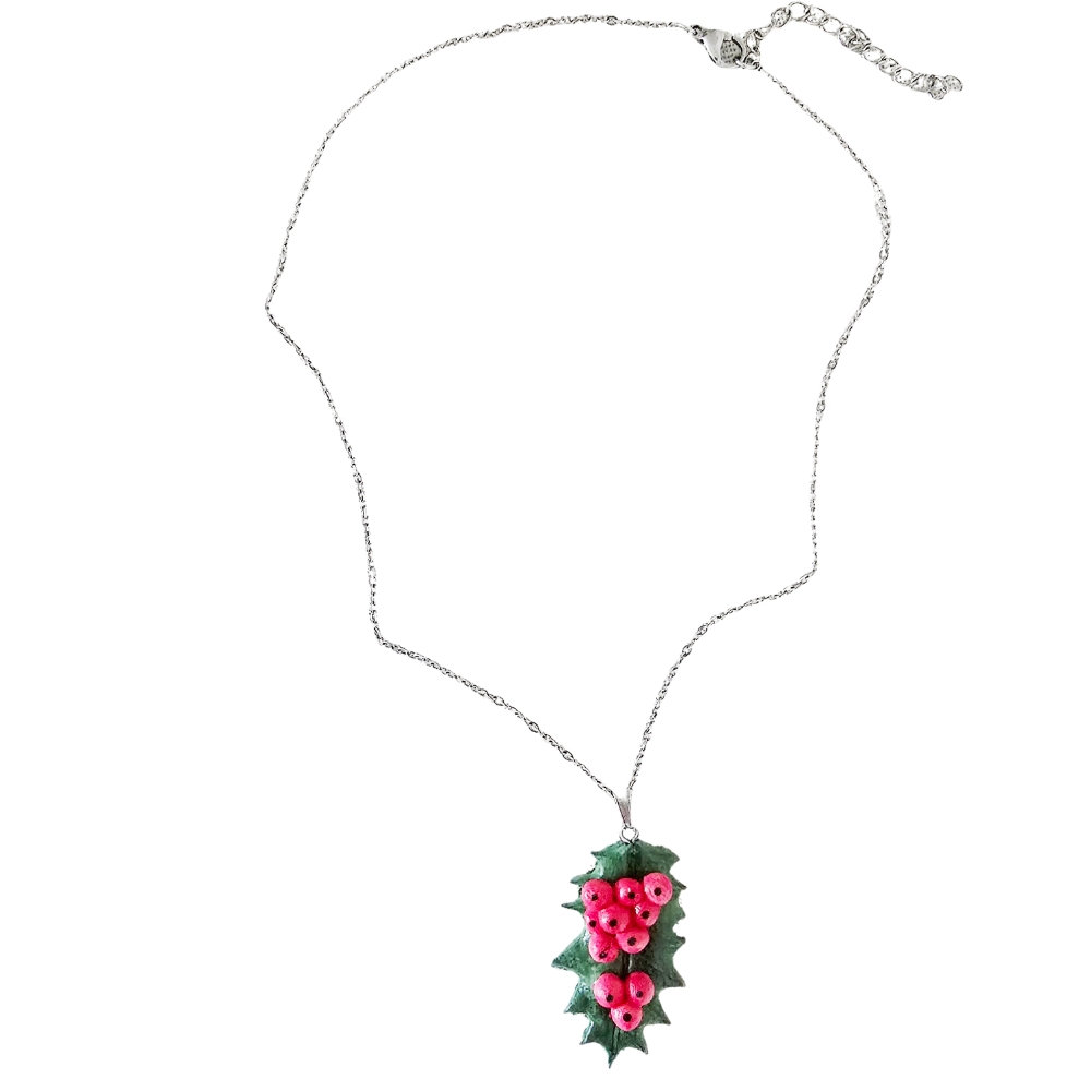 Holly necklace on white background — handmade evergreen pendant with red berries