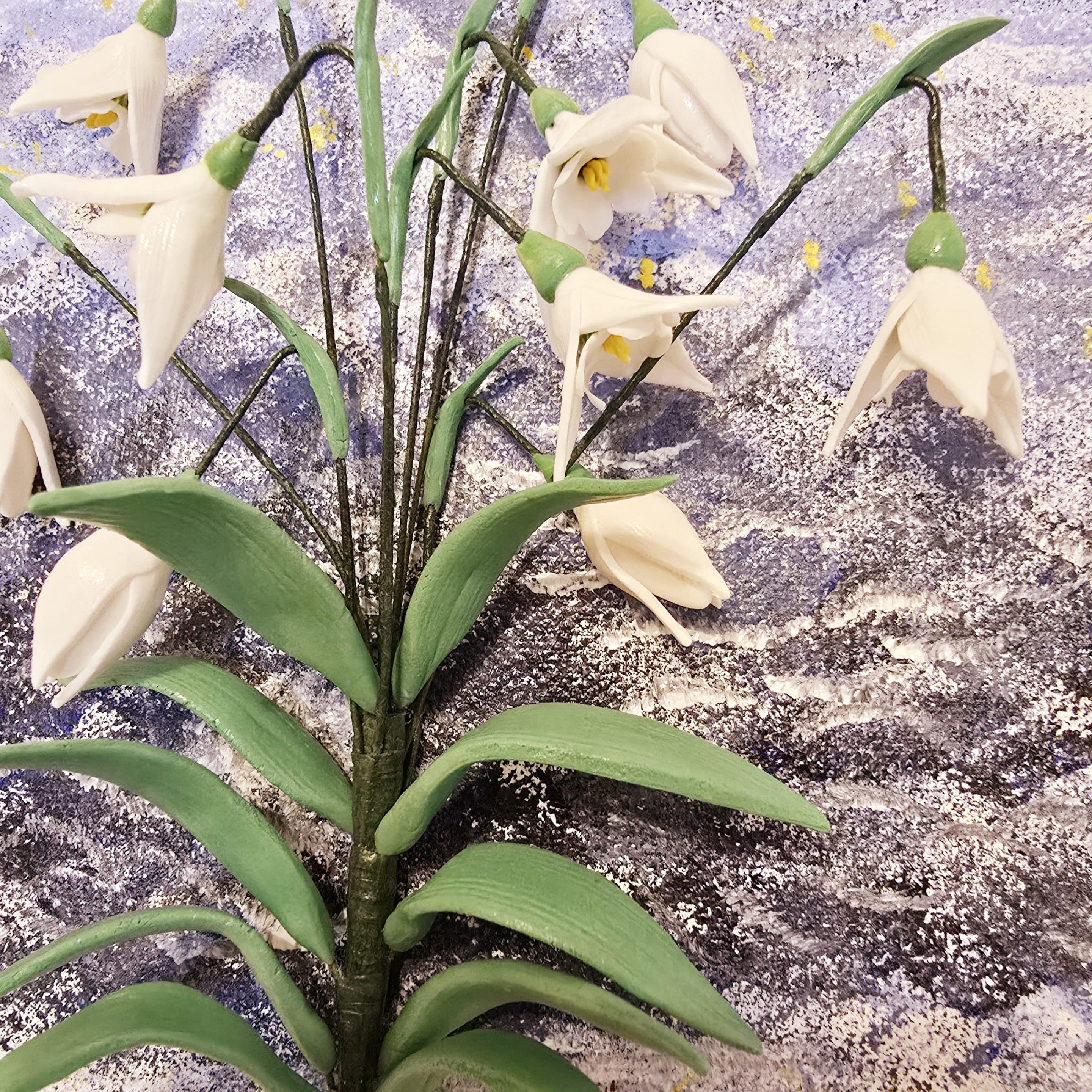 Close-up of snowdrop flowers made from air dry clay, with delicate buds and hand-painted details.