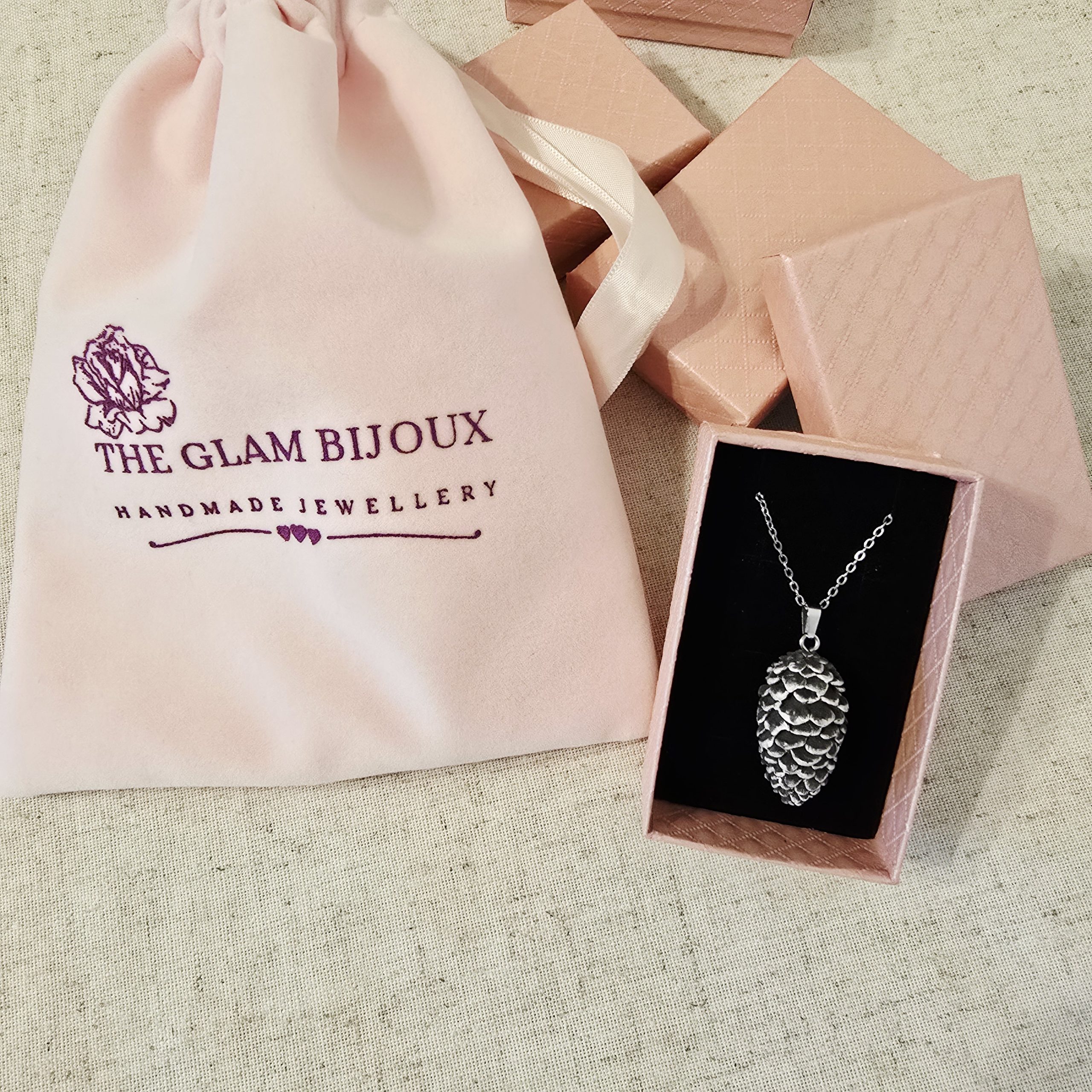 Pinecone Necklace by The Glam Bijoux inside elegant gift box and pink velvet pouch.