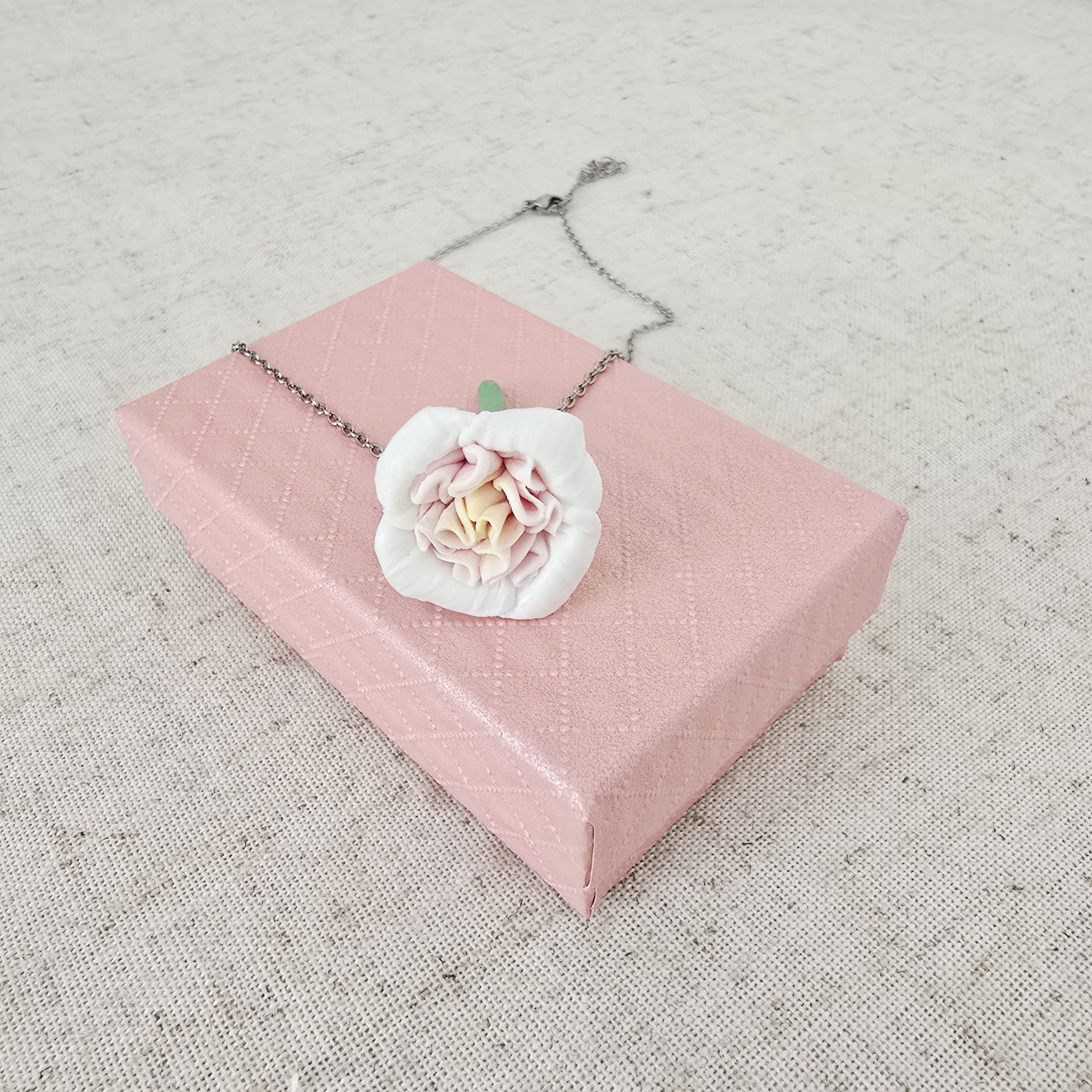 Elegant english garden rose pendant necklace displayed on a jewelry stand by The Glam Bijoux.