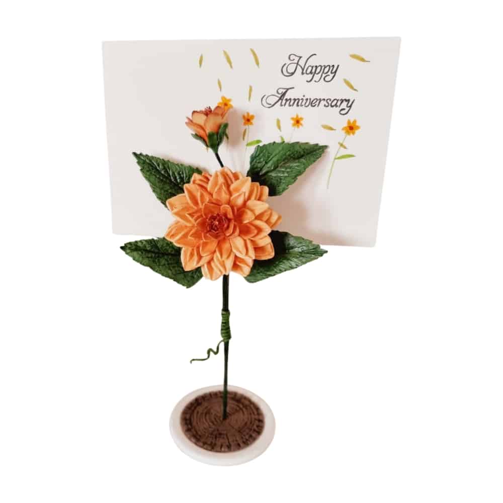 Beautiful handcrafted clay dahlia flower in a glass holder, perfect for home decor.